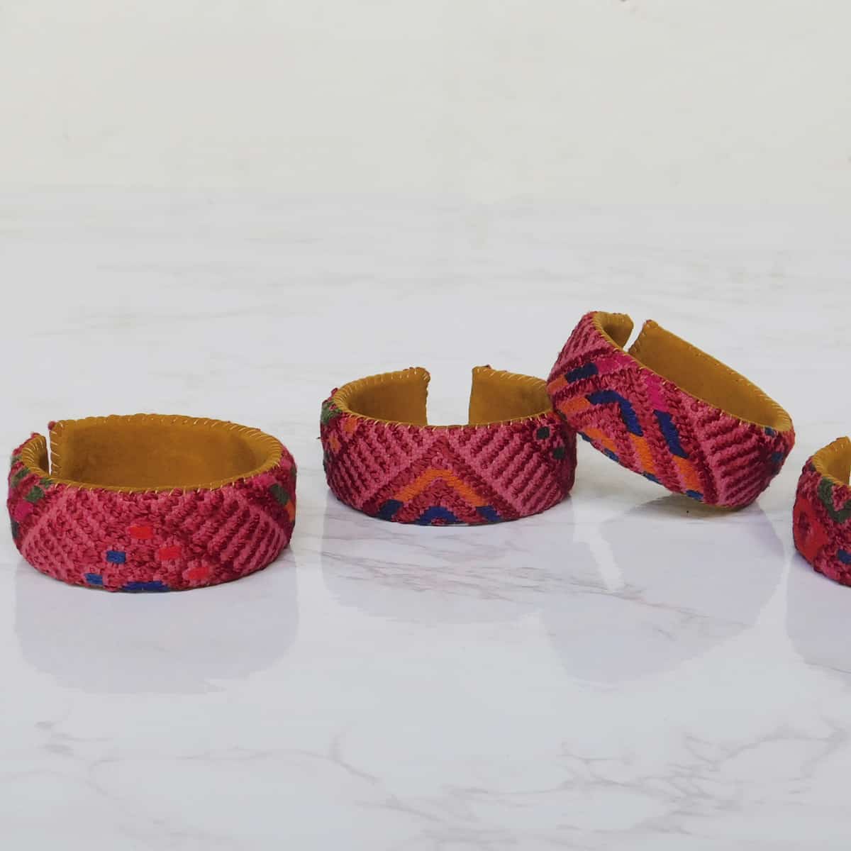 A set of four leather forearm cuffs with red corte fabric from Guatemala