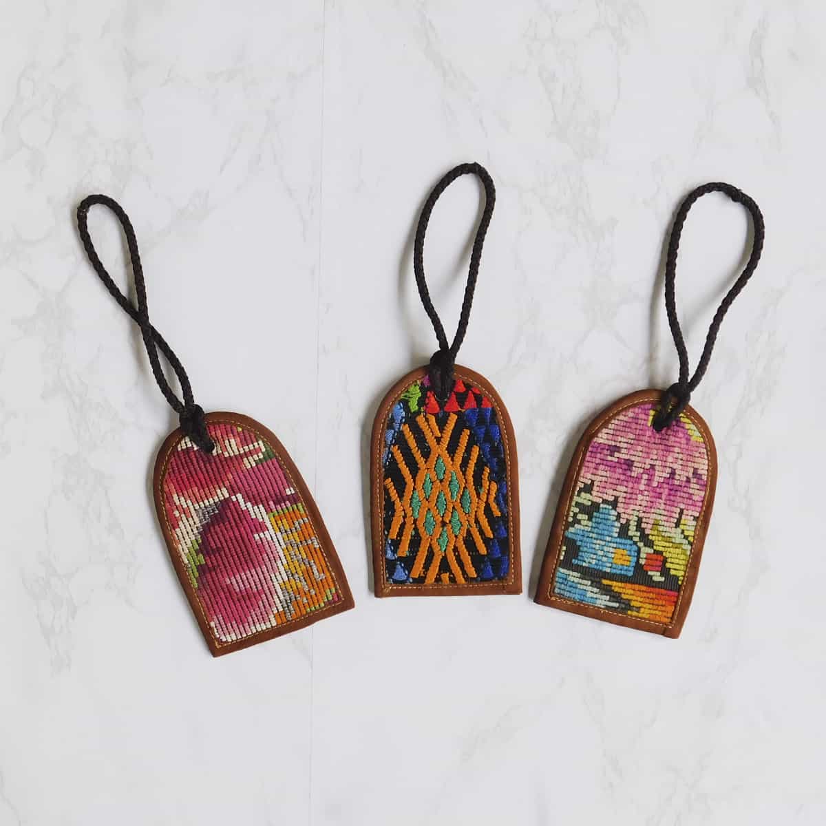 handmade leather luggage tags from guatemala with huipil fabric
