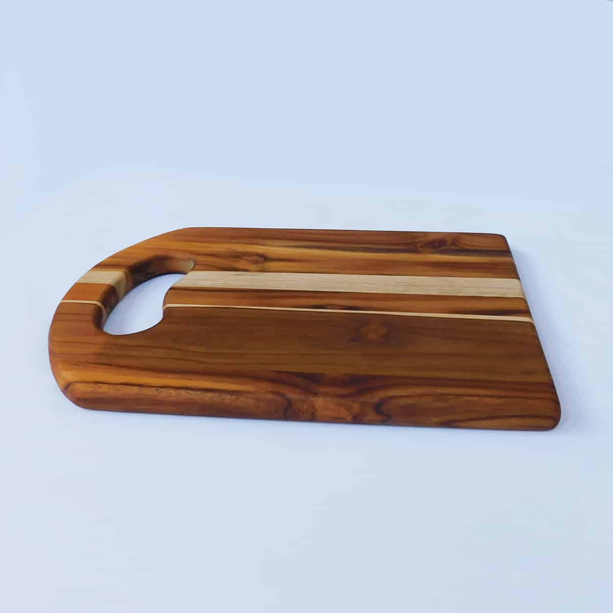 side view of wood serving board with cutout handle on white background