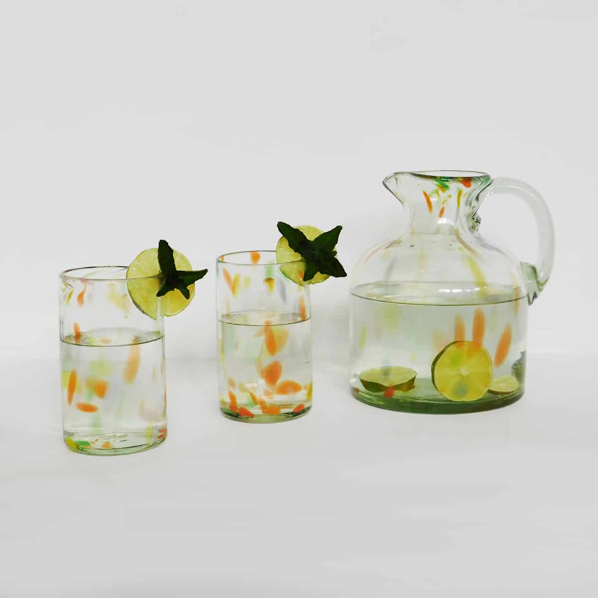 two hand blown glasses and recycled glass pitcher on white background