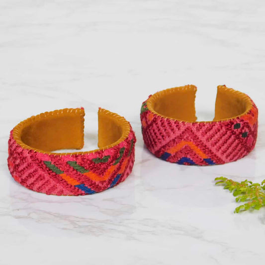 A bohemian bracelet with red corte fabric on a leather backing