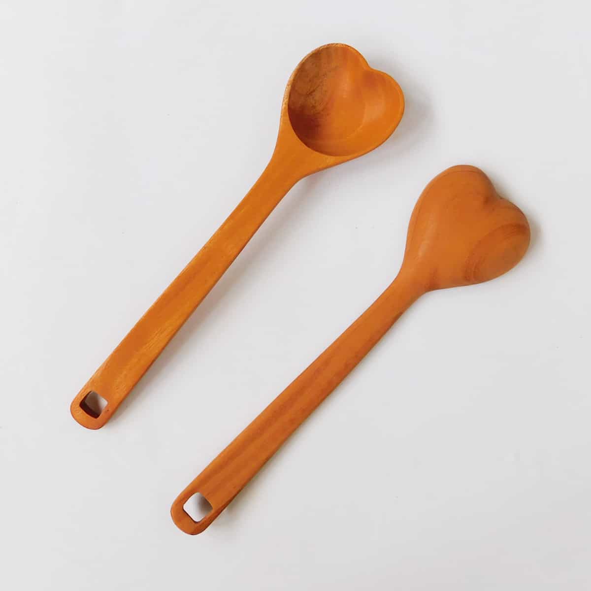 a wood spoon set of two with the ladle in a shape of a heart