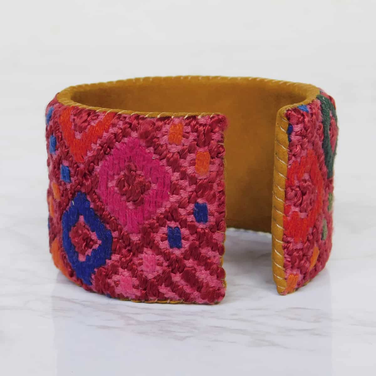 opening of a wide leather cuff bracelet featuring red typical fabric from guatemala