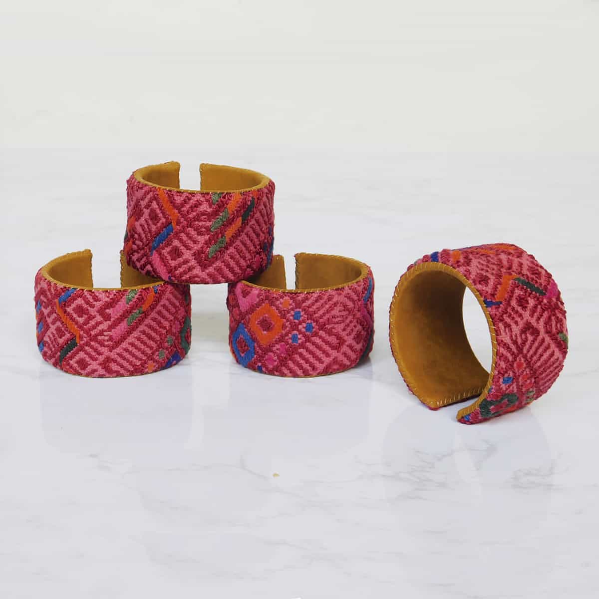 four red cuff bracelets made by hand in guatemala with red huipil fabric featuring diamond shapes