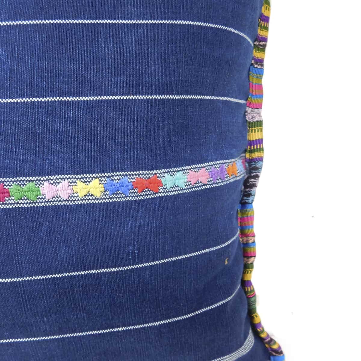 hand embroidered decorative bands on a navy blue woven pillow,