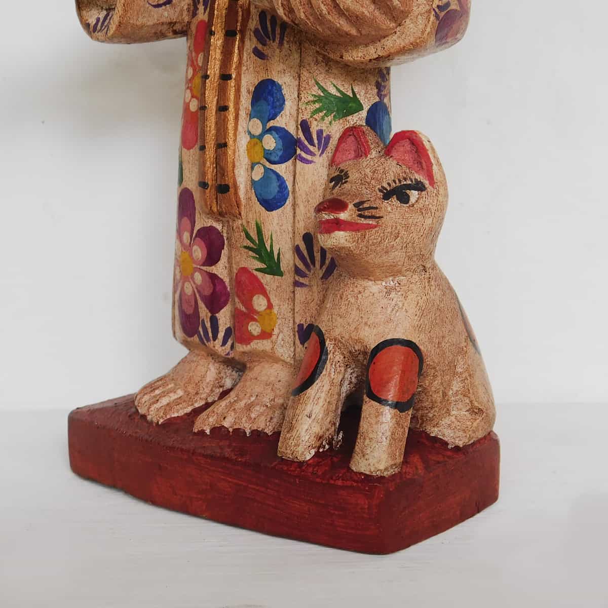 carved wooden figurine fo a cat next to saint francis figurine