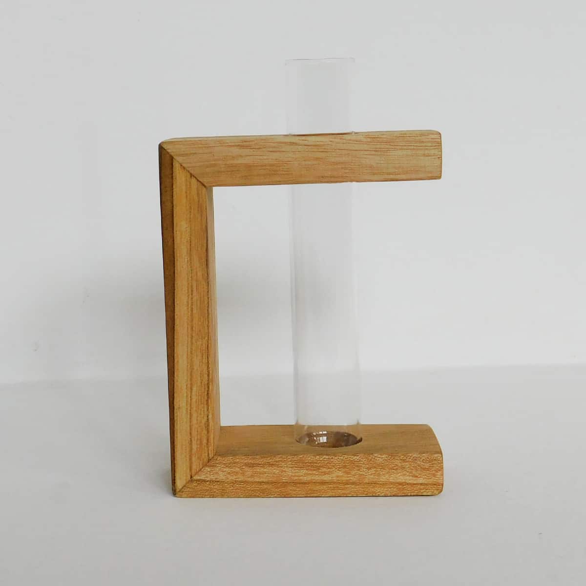 a glass test tube plant holder is supported in a three sided teak wood frame